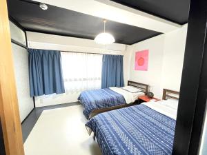1 dormitorio con 2 camas y ventana en Beppu Story - Family Room 3 -, en Beppu