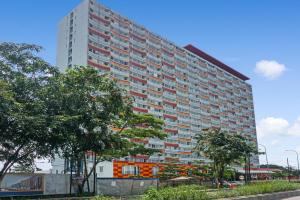 a large apartment building with red and white windows at Super OYO 91045 Tower Mahakam in Bekasi