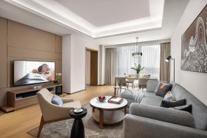 a living room with a couch and a tv at Ascott M-City Foshan in Foshan