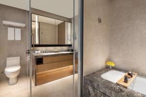 a bathroom with a toilet and a sink and a shower at Ascott M-City Foshan in Foshan