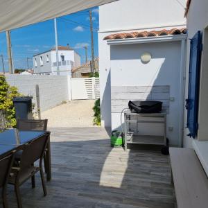 a patio with a table and chairs and a building at Maison typique vendéenne in La Tranche-sur-Mer