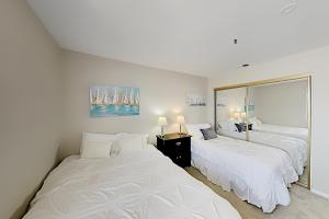 Un dormitorio con dos camas y un gran espejo. en Imperial Beach Club Unit 303 Oceanfront condo, direct beach access, pool, hot tub, & private balcony, en Imperial Beach 15 fotos más
