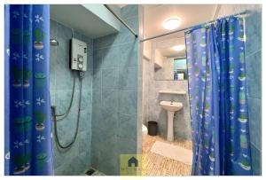 a bathroom with a shower with a blue shower curtain at Hooman Hostel in Chiang Mai
