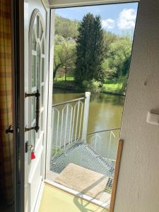 a door to a balcony with a view of a river at Doppelzimmer an der Lahn ohne Küche in Obernhof