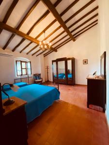 a large bedroom with a blue bed and wooden ceilings at Agriturismo “Sterrati” in Valpiana