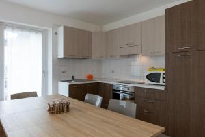 a kitchen with wooden cabinets and a wooden table at Maison Maurice in Aosta