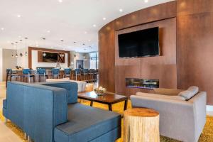 a living room with blue furniture and a fireplace at Cambria Hotel Bloomington Mall of America Minneapolis Airport in Bloomington