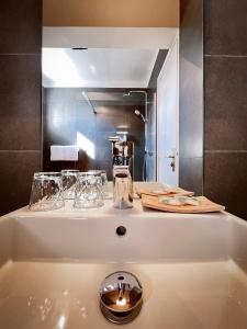 a bath tub with glasses on top of it at Hotel l'Isolella in Porticcio