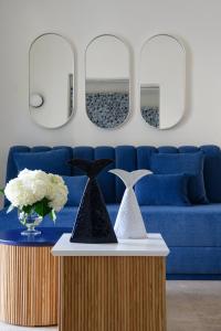 a living room with a blue couch and two mirrors at La Residenza Capri in Capri