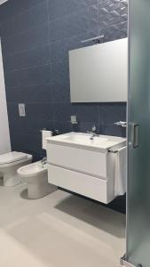 a bathroom with a white sink and a toilet at Dependance La Mouette in Termini Imerese