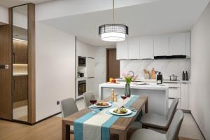 a kitchen and dining room with a table and chairs at Ascott M-City Foshan in Foshan