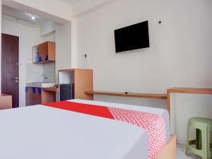 um quarto com uma cama e uma televisão na parede em Super OYO 91045 Tower Mahakam em Bekasi