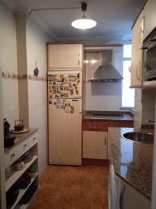 a kitchen with a refrigerator with stickers on it at Precioso apartamento en Santander cerca de todo in Santander