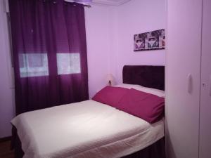 a small bedroom with two beds and a window at Precioso apartamento en Santander cerca de todo in Santander