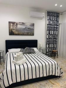 a bedroom with a bed with a black and white striped blanket at Di Palma Suite Museum in Naples