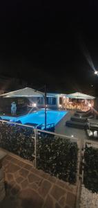 una gran piscina por la noche con sombrillas en Foresterie Lombarde B&B Villa Ambra, en Limbiate