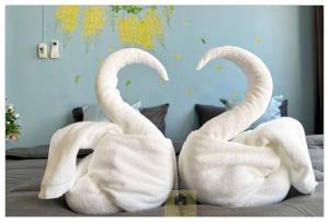 two towel swans are sitting on a bed at Hooman Hostel in Chiang Mai