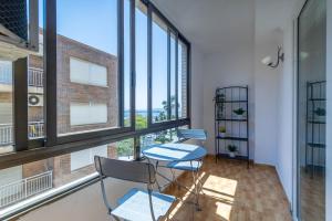 Unique Hotel Apartments في توريفايجا: كرسيين وطاولة في غرفة مع نوافذ كبيرة
