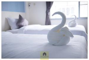 a white swan statue sitting on top of a bed at Hooman Hostel in Chiang Mai