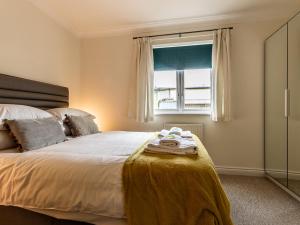 a bedroom with a large bed with a window at Pass the Keys Stylish holiday townhouse by the Quay with parking in Exeter
