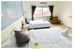 a hotel room with two beds and a window at Hooman Hostel in Chiang Mai