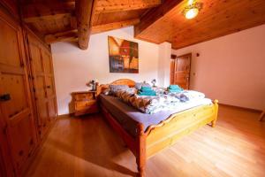 ein Schlafzimmer mit einem Bett in einem Zimmer mit Holzdecken in der Unterkunft Appartamenti Valeria 1 in Livigno