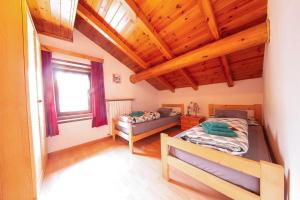 two beds in a room with wooden ceilings at Appartamenti Valeria 1 in Livigno