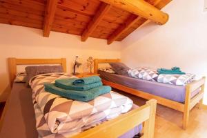 2 Betten in einem Zimmer mit Holzdecken in der Unterkunft Appartamenti Valeria 1 in Livigno