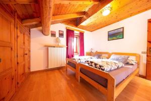 a bedroom with a bed in a room with wooden ceilings at Appartamenti Valeria 1 in Livigno
