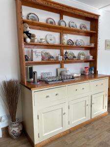 a shelf filled with plates and dishes in a room at Whiteways Guest House in Skegness