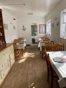 a dining room with tables and chairs and a kitchen at Whiteways Guest House in Skegness