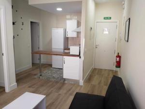 a room with a kitchen with a counter and a table at KubiK APARTAMENTOS K2 in Cáceres