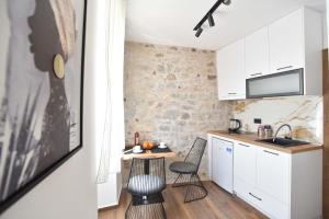a kitchen with a table and chairs in a room at Sambra old town apartment in Budva