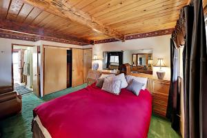 een slaapkamer met een groot bed en een rode deken bij Summit Basecamp in Big Bear Lake