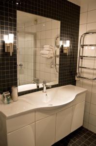 y baño con lavabo blanco y espejo. en Quality Hotel Olavsgaard en Skjetten