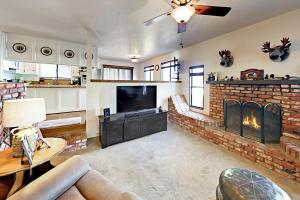 a living room with a brick fireplace and a tv at Lazy Bear Cabin in Big Bear Lake