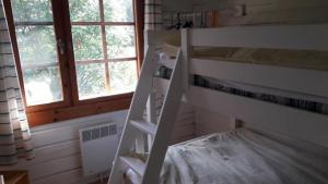 a bunk bed in a room with a ladder at Mellangårds stugor - Stockstugan in Föglö