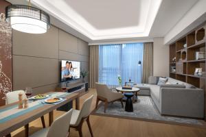 a living room with a couch and a table at Ascott M-City Foshan in Foshan