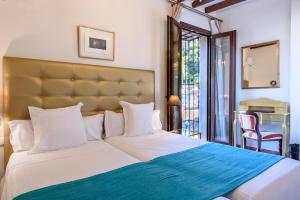 ein Schlafzimmer mit einem großen Bett mit einer blauen Decke in der Unterkunft Palacio de Santa Inés in Granada