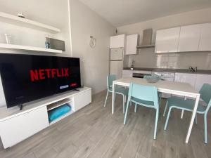 a kitchen with a table and chairs and a television at Apartamento MEDAL in El Cotillo