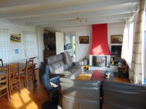 a living room with a leather couch and a fireplace at Polderhuis voor 8-10 personen aan zee in Nieuwvliet