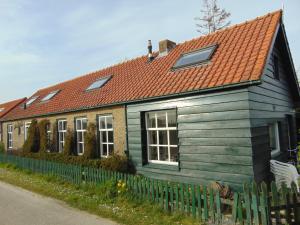 a wooden house with an orange roof at Polderhuis voor 8-10 personen aan zee in Nieuwvliet