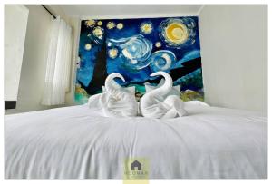 two white swans sitting on top of a bed at Hooman Hostel in Chiang Mai