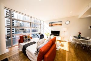 sala de estar con cama y ventana grande en Superb 1 bed apartment in Syd CBD Darling Harbour, en Sídney