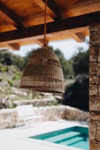 a straw hat hanging from a roof over a pool at Villa Kadila with heated pool and sauna for family in Lun