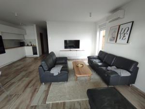 Sala de estar con 2 sofás y mesa de centro en Panorama Residence, en Opatija