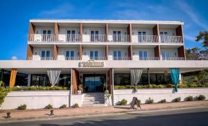 a large white building on the side of the street at Hotel l'Isolella in Porticcio