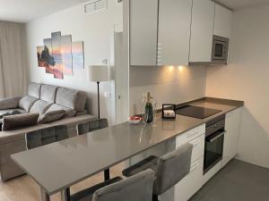 una cucina e un soggiorno con tavolo e divano di Brand new apartment with gym&rooftop pool. a Marbella