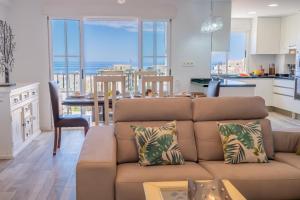 Una sala de estar con un sofá y una cocina. en Panamanian Blue Sea View Flat, en La Herradura