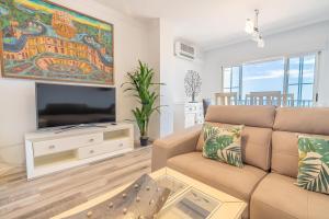 Una sala de estar con un sofá y un televisor de pantalla plana. en Panamanian Blue Sea View Flat, en La Herradura